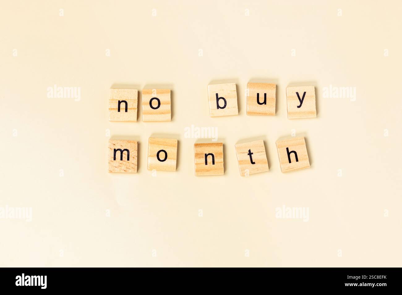 Lettere di legno che scrivono "no buy", spese consapevoli e consapevolezza finanziaria nella vita di tutti i giorni Foto Stock