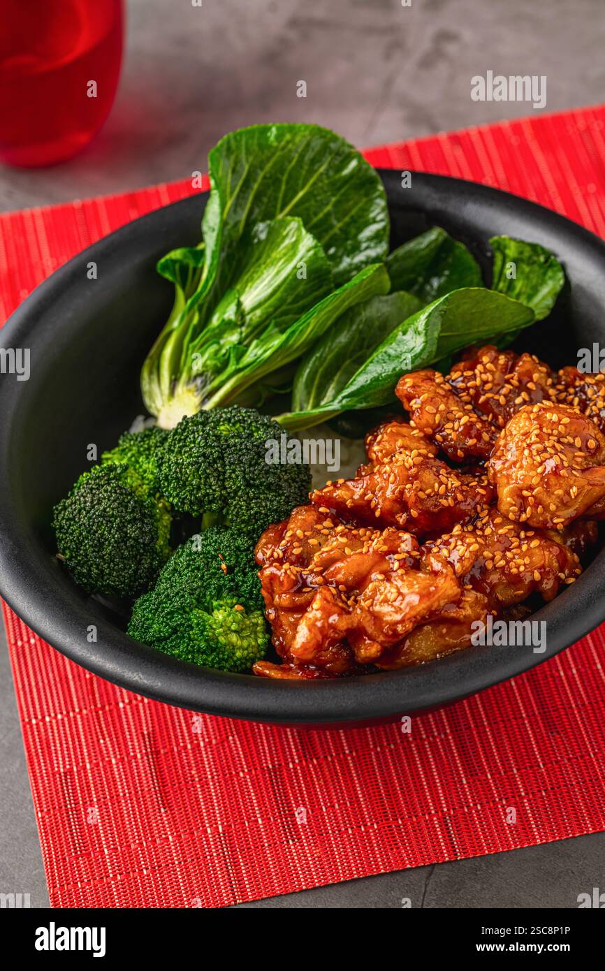 Ciotola di pollo Teriyaki con broccoli e bok choy su un tavolo in pietra grigia Foto Stock