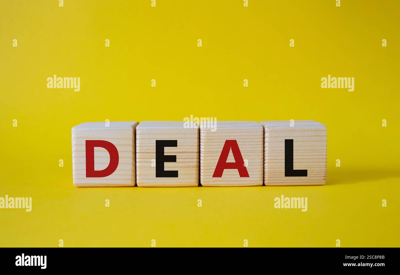 Simbolo dell'accordo. Concept Word deal su cubi di legno. Bellissimo sfondo giallo. Concetto di affari e affari. Copia spazio. Foto Stock