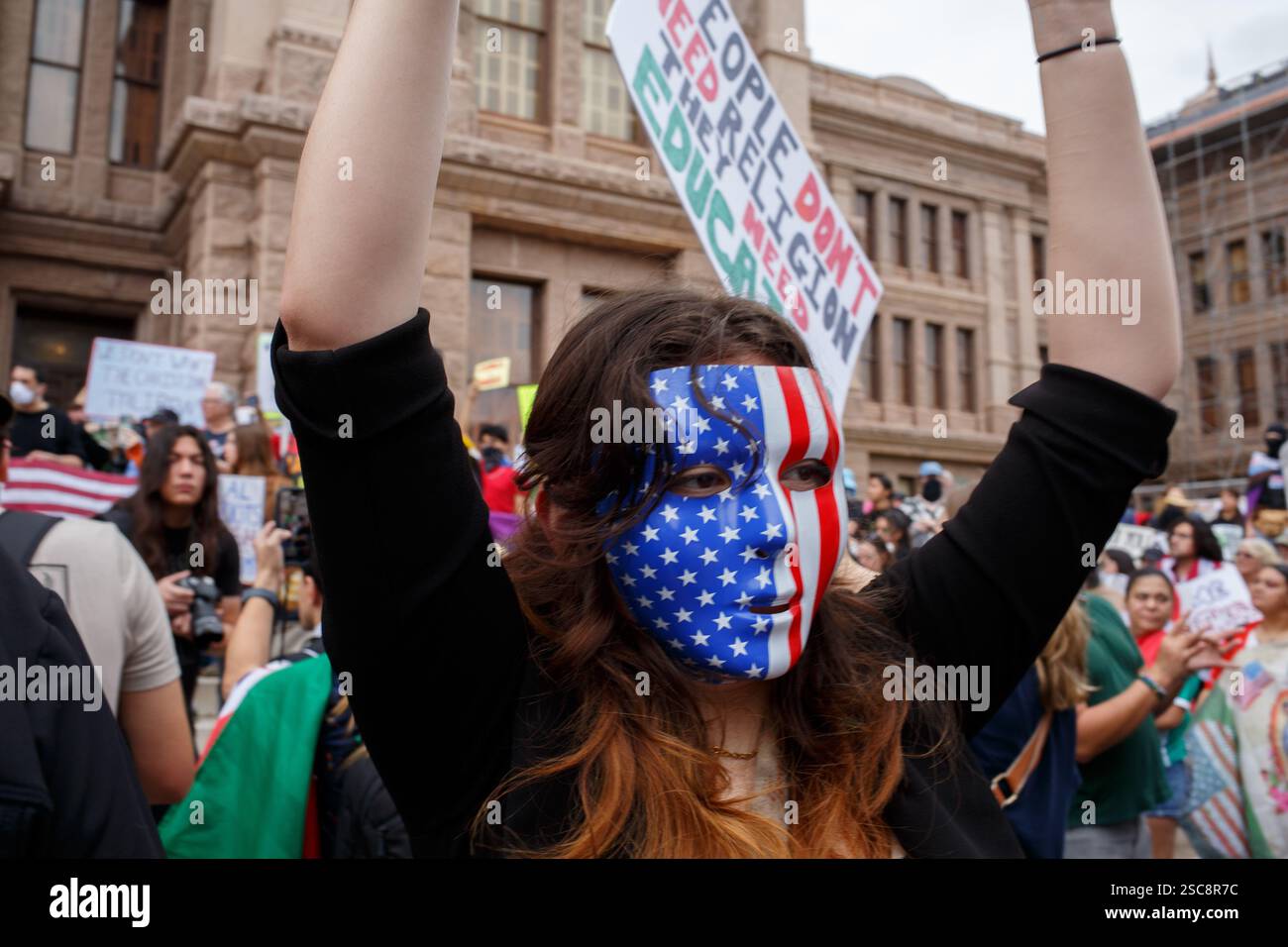 Austin, Texas, Stati Uniti. 5 febbraio 2025. Una donna che indossa una maschera decorata con le stelle e le strisce attraversa la folla durante la protesta contro le politiche del presidente Trumps nei confronti di LGQT, Gay, Trans e immigrati. La protesta fa parte di 50 proteste simultanee in tutti i Capitoli di stato sponsorizzate dall'organizzazione del 50501. (Credit Image: © Jaime Carrero/ZUMA Press Wire) SOLO PER USO EDITORIALE! Non per USO commerciale! Foto Stock