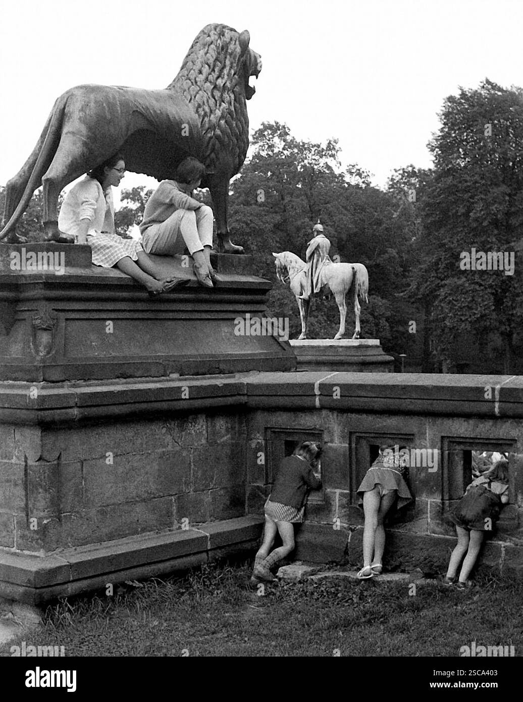 Copia del Brunswick Lion davanti al palazzo imperiale di Goslar durante la giornata dell'Europa. La figura mostra i bambini guardando attraverso i fori. Foto Stock