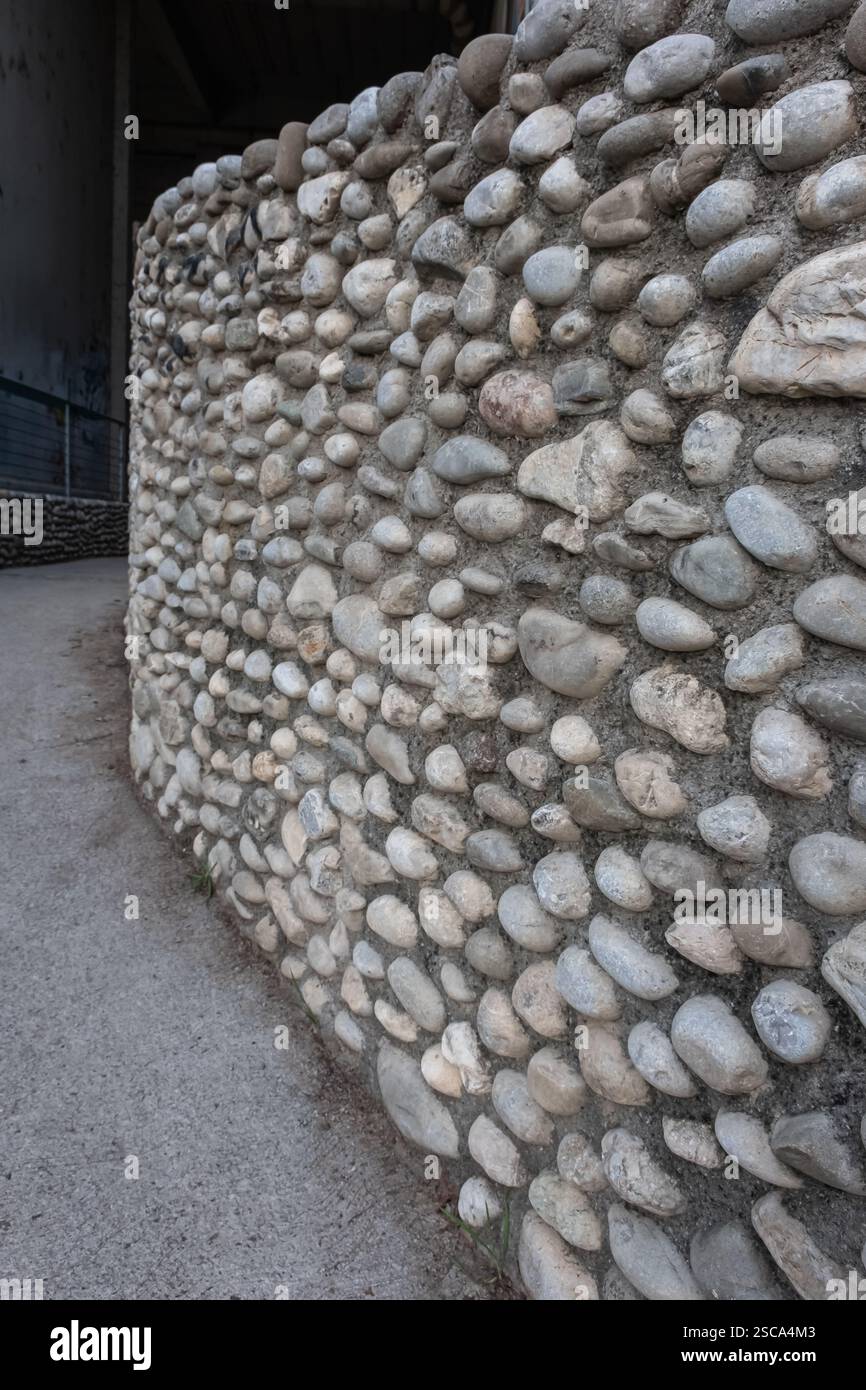 Parete esterna dell'edificio. Sfondo da parete in pietra. Tradizionale muro di pietra e fango. Muro fatto di pietre e ciottoli Foto Stock