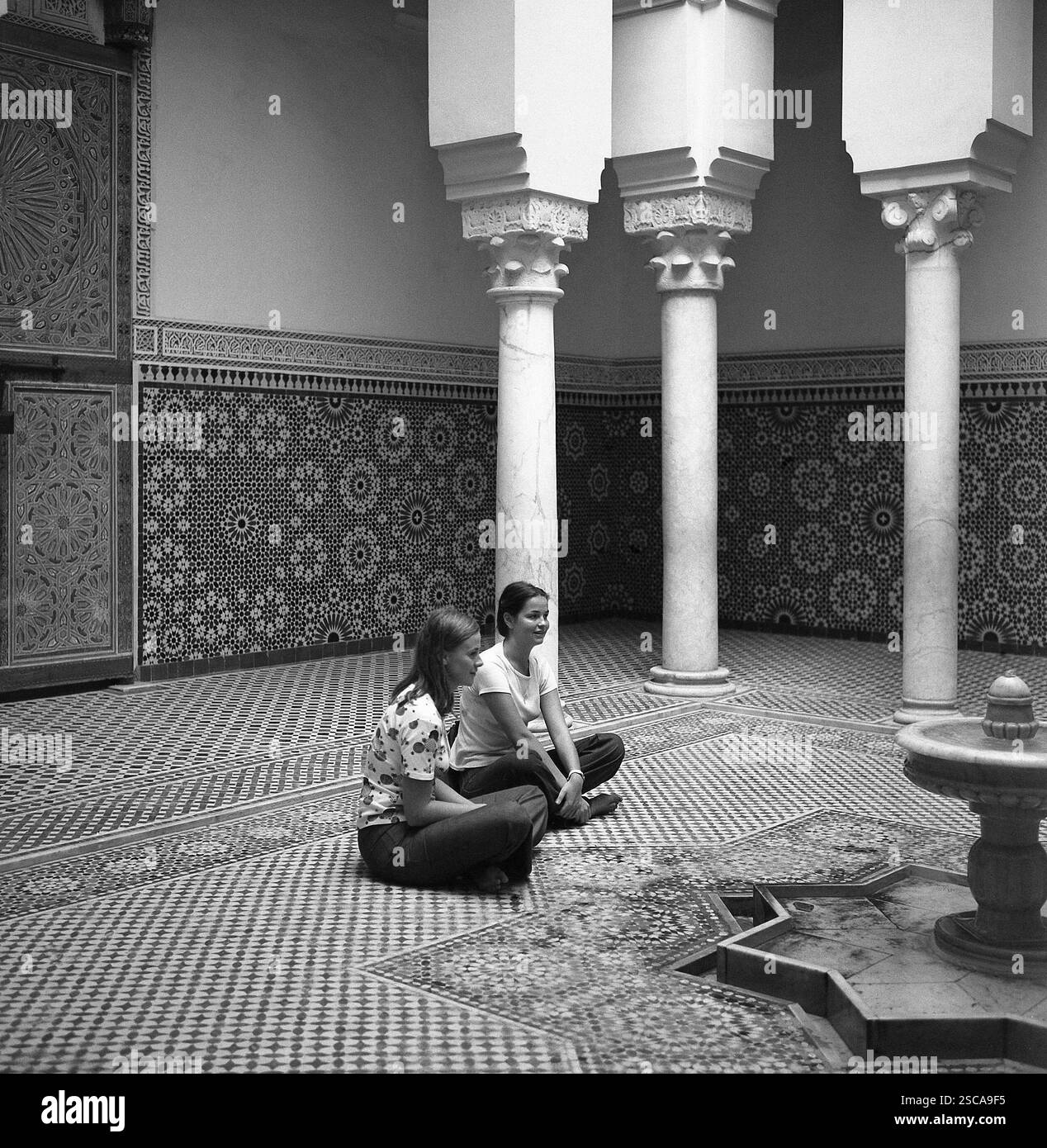 Le donne sedute a terra di fronte a una fontana in un palazzo a Meknes in Marocco. Foto Stock