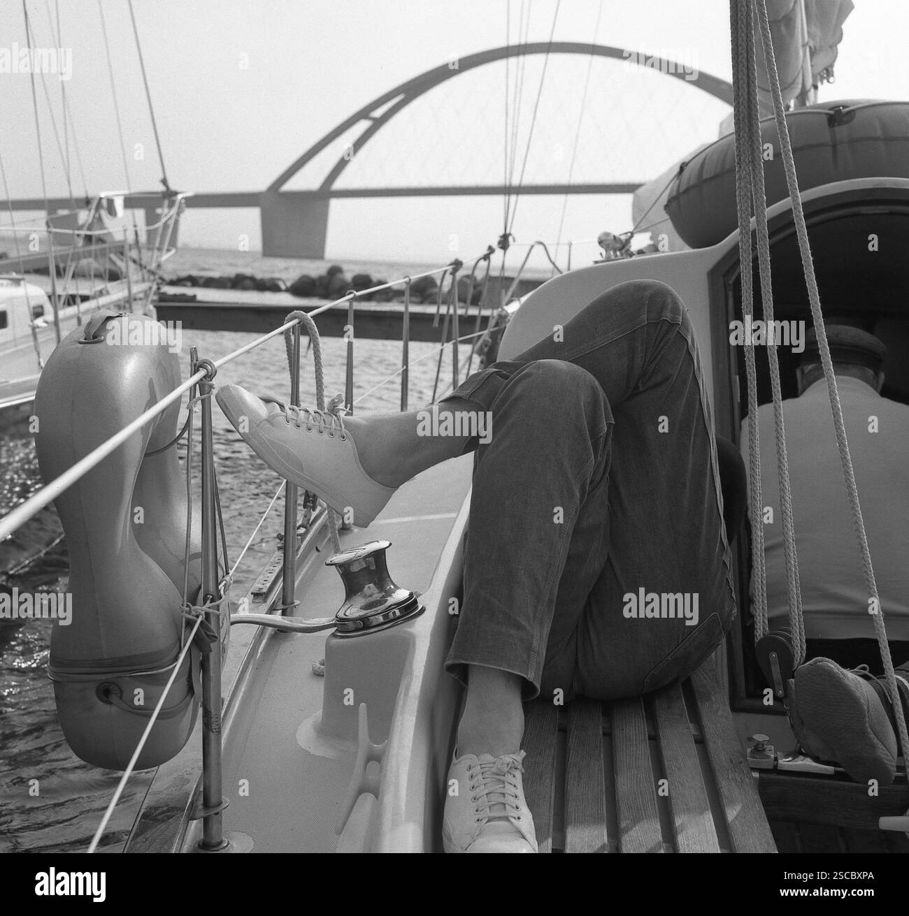 Una persona prende il sole su una barca in un porto sul Fehmarnsund. [traduzione automatica] Foto Stock