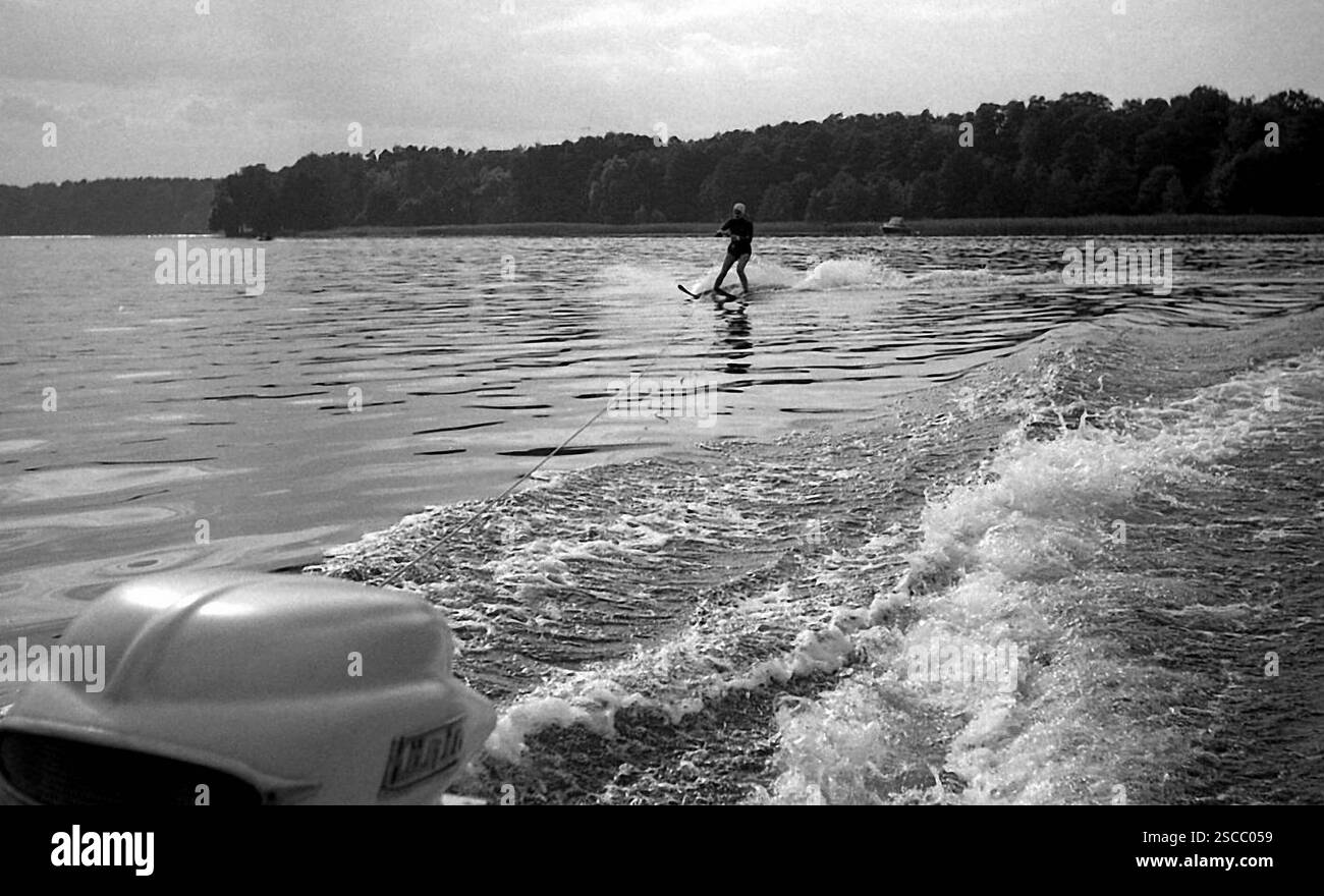 Acqua sciatore con tappo di balneazione su Scharmuetzelsee nel Brandeburgo e nella parte anteriore del motore di un motoscafo. Foto Stock
