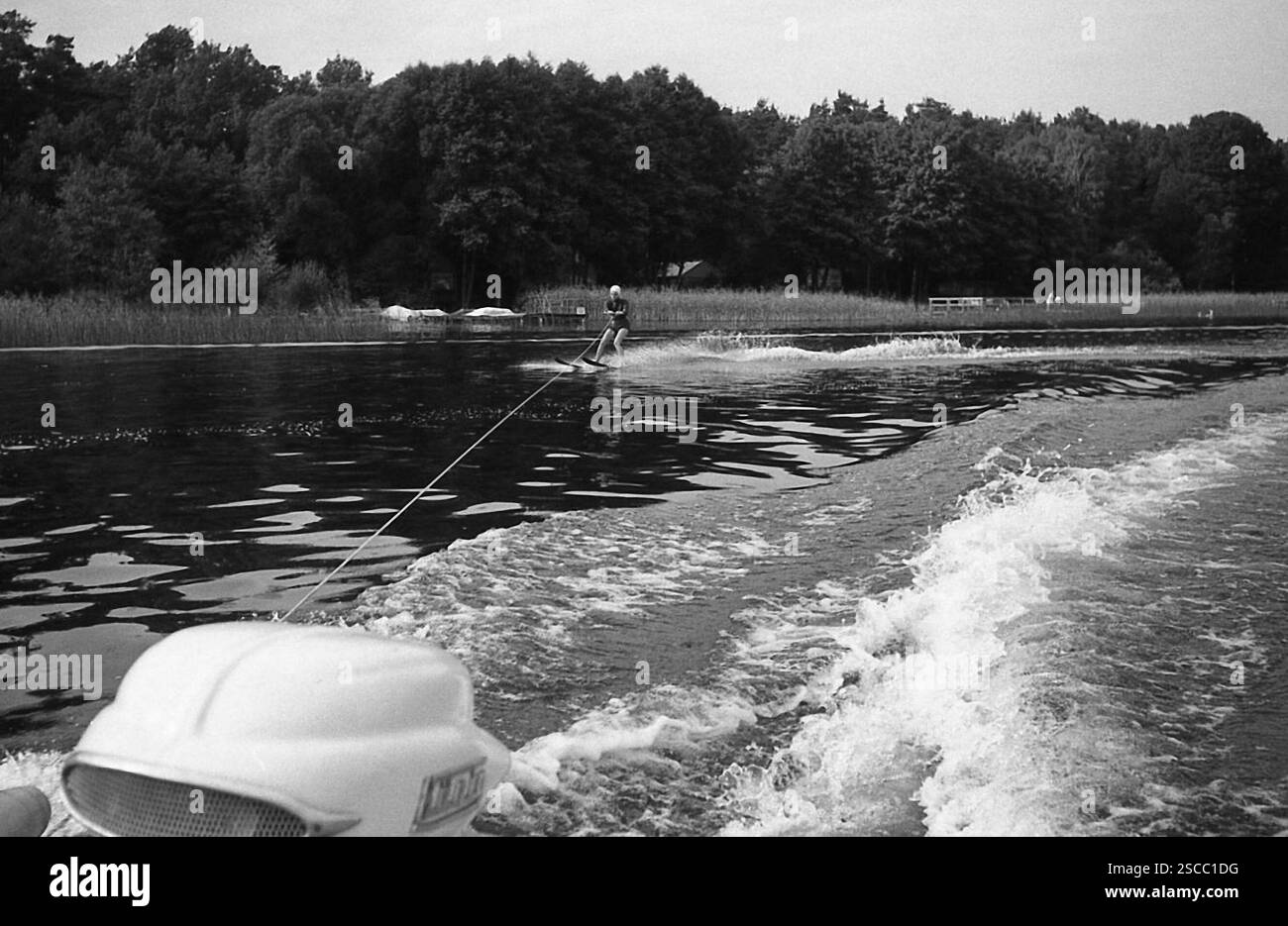 Acqua sciatore con tappo di balneazione su Scharmuetzelsee nel Brandeburgo e nella parte anteriore del motore di un motoscafo. Foto Stock