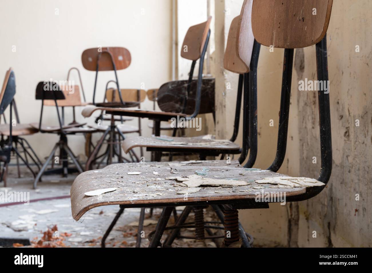 Sedie sporche in una stanza abbandonata in legno con struttura in metallo, esplorazione urbana Foto Stock