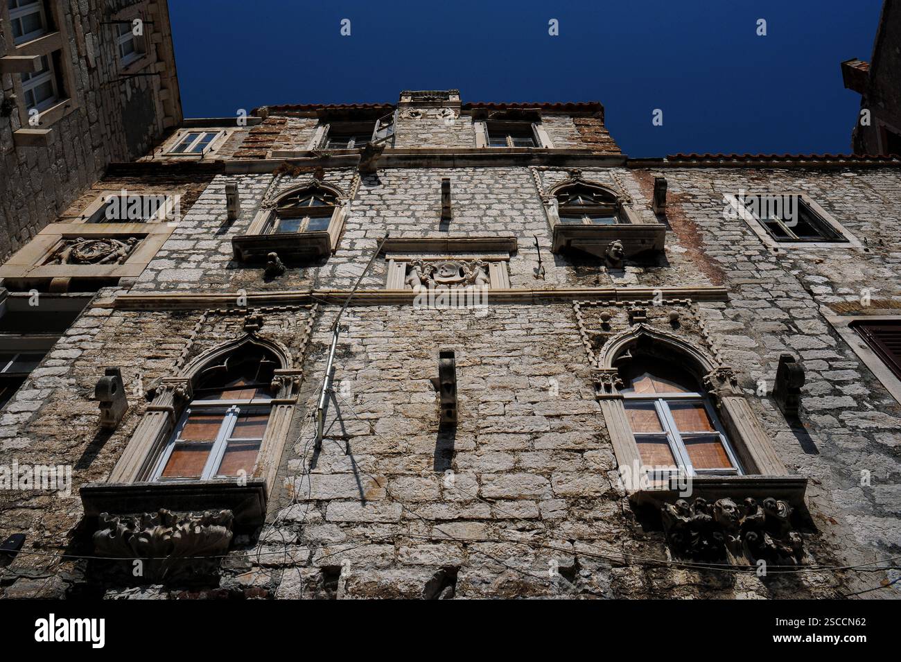 Un teschio su uno scudo di garlanded tenuto da due cherubini sulla facciata del palazzo gotico veneziano Foscolo può simboleggiare il cervello umano e la frase "Usa il cervello e vinci", piuttosto che la morte. Il palazzo del XV secolo a Šibenik, Dalmazia, Croazia, fu la casa di Leonardo Foscolo (1588 - 1660), Capitano generale da Mar o Capo ammiraglio della flotta della Repubblica di Venezia. Foto Stock