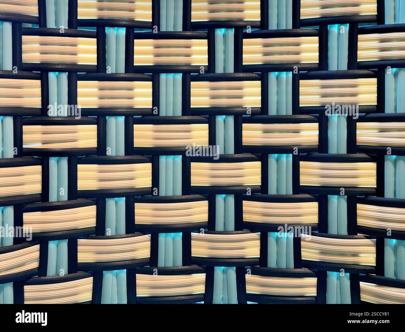 Primo piano della tessitura sintetica in rattan o vimini in vari motivi, blu, nero e bianco. Sfondo in rattan intrecciato a mano senza cuciture. Foto Stock