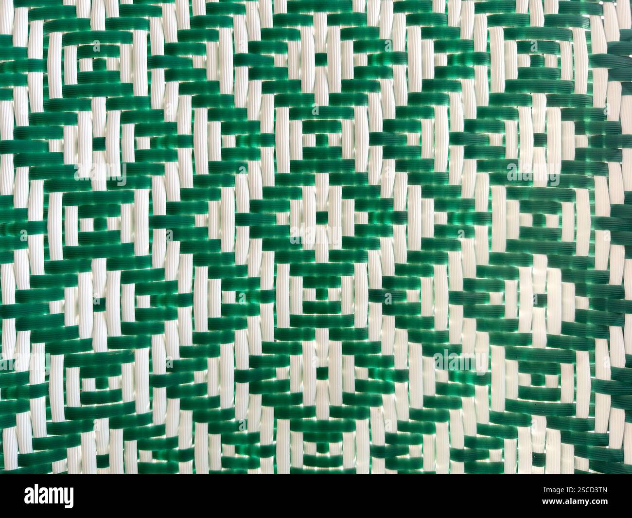 Primo piano di intrecci sintetici di rattan verde e bianco o vimini con motivo a chevron e diamante. Sfondo in rattan intrecciato a mano senza cuciture. Foto Stock