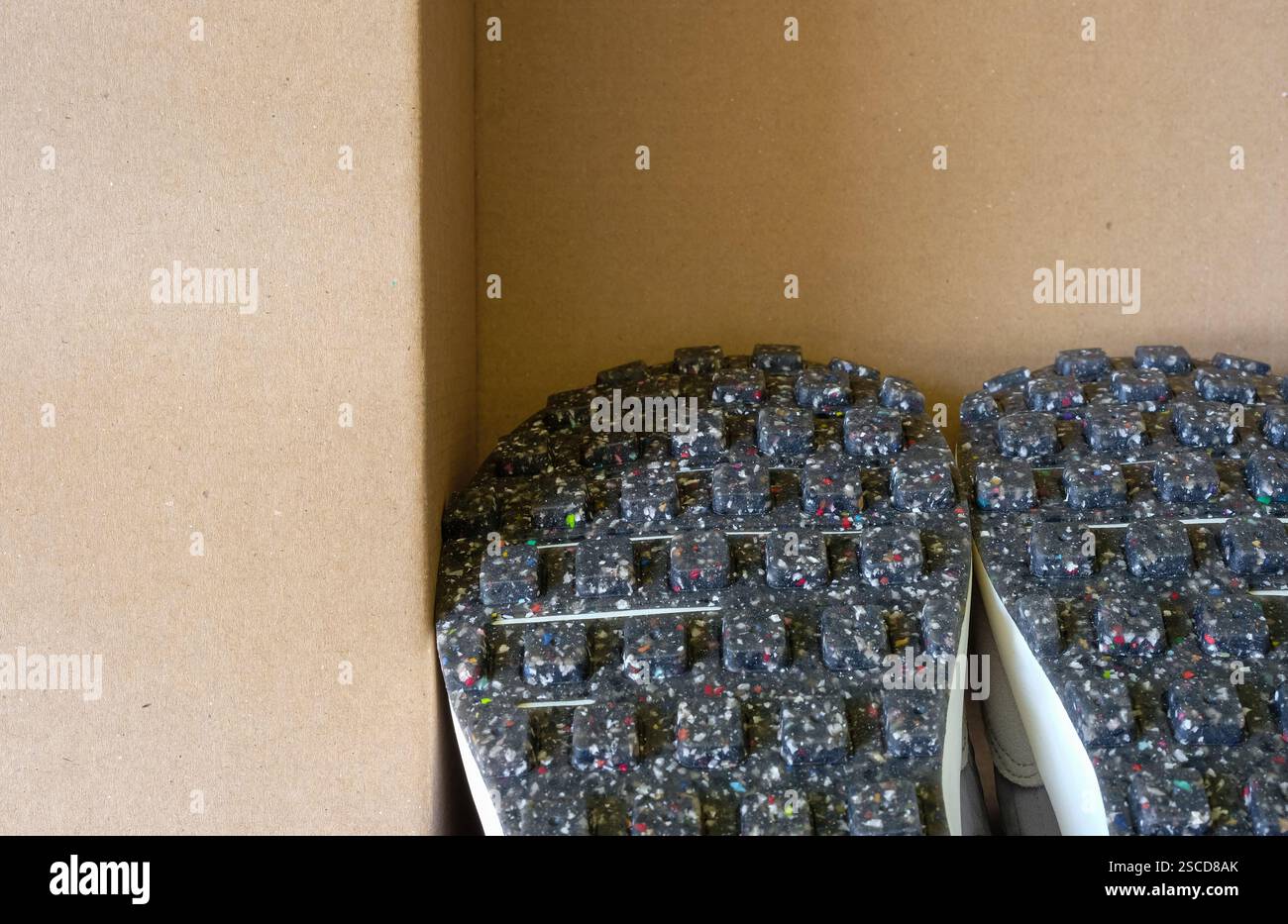 Scarpe vegane nella scatola biodegradabile. Le suole includono prodotti di contenuto riciclato. Impronta di carbonio. Copia spazio. Foto Stock