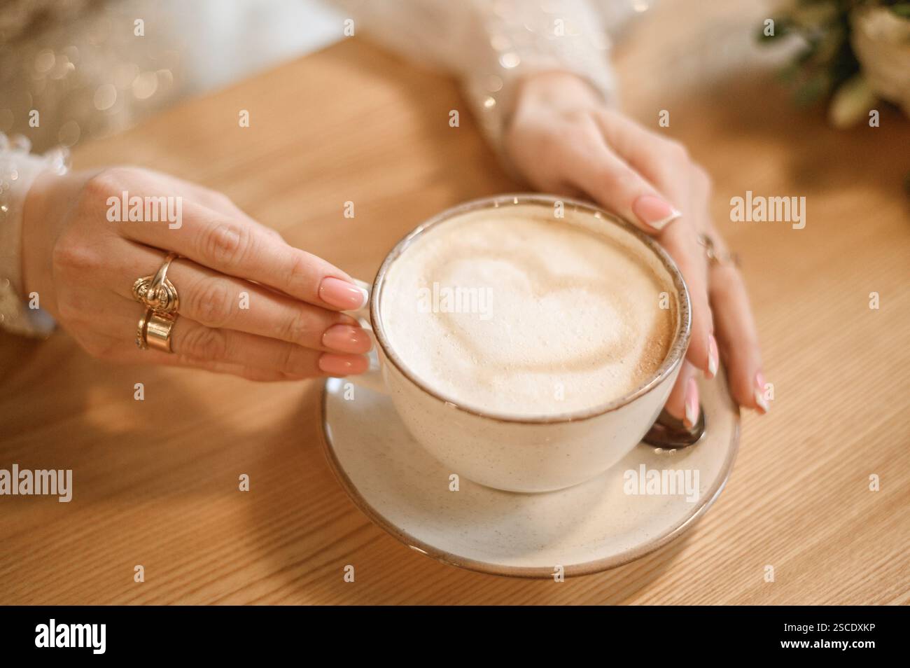 Tazza di caffè cappuccino e bella Heart latte Art, in mani femminili. Il concetto di San Valentino Foto Stock