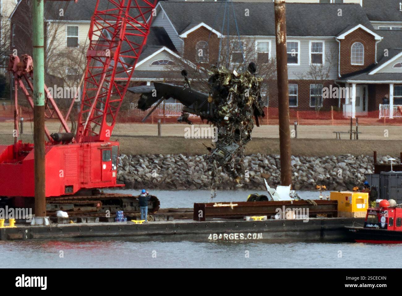 Rescue and salvage crews pull up a part of a Army Black Hawk helicopter ...