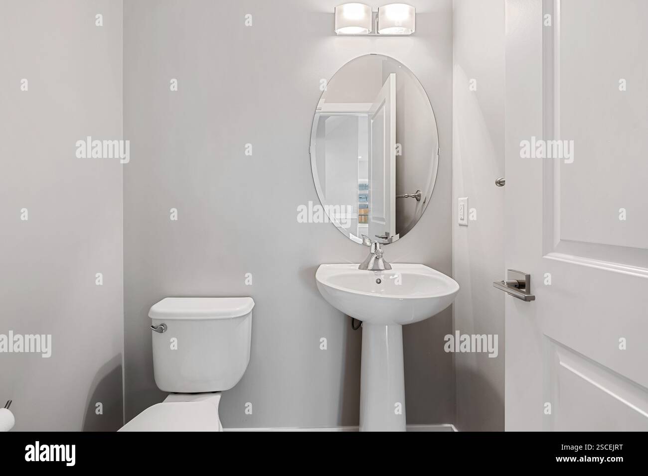 Bagno con WC bianco e lavandino. Il bagno era pulito e ben illuminato Foto Stock