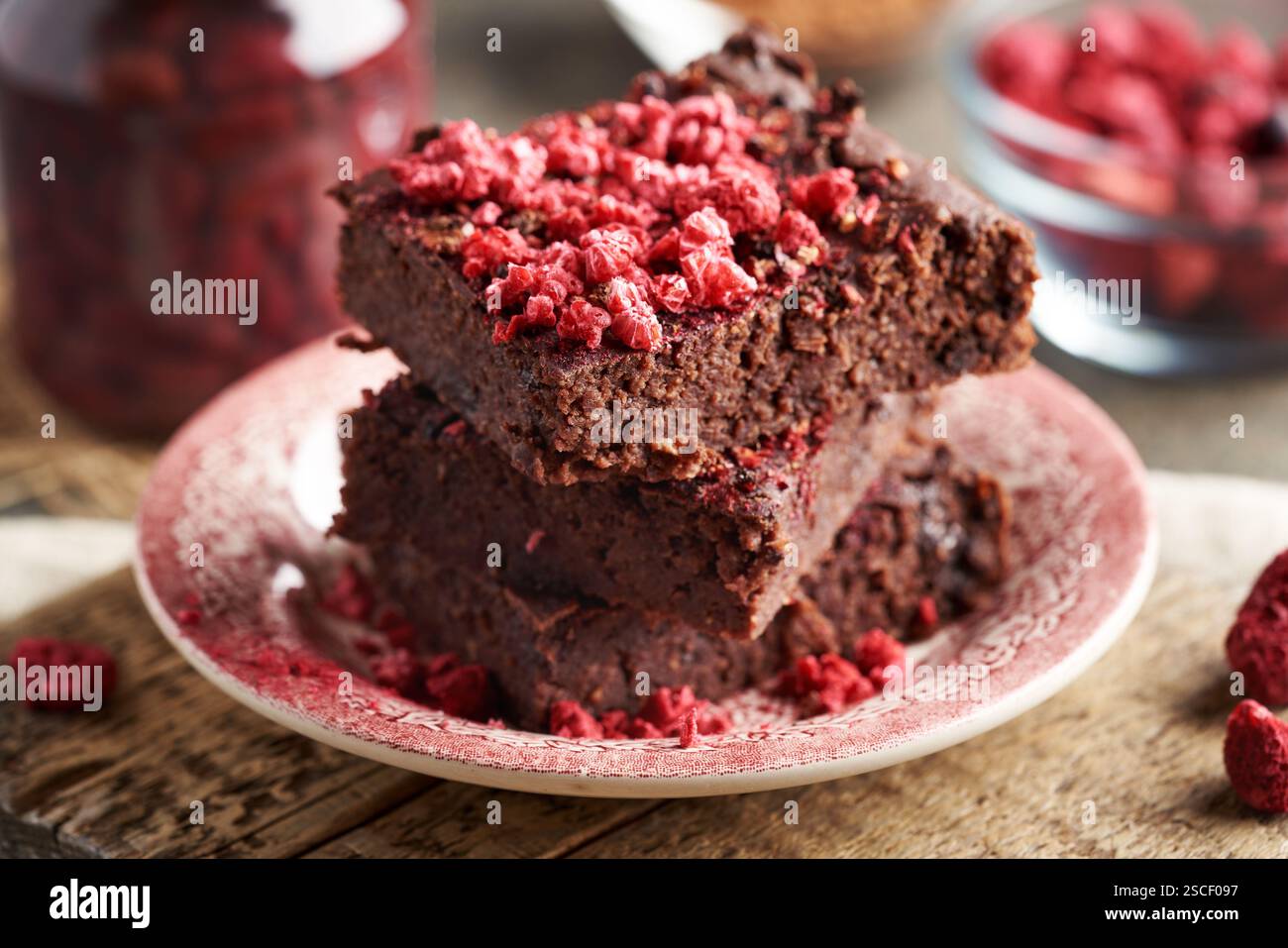 Brownie senza glutine fatti in casa, realizzati con fagioli rossi, fiocchi d'avena e cioccolato, ricoperti di lamponi liofilizzati Foto Stock