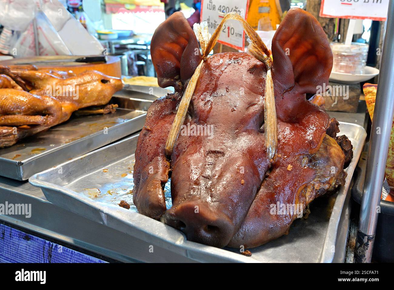 La brasatura è una tecnica di cucina tradizionale cinese con una lunga storia culinaria, vista qui con un piatto di testa di maiale e carne d'anatra sullo sfondo Foto Stock
