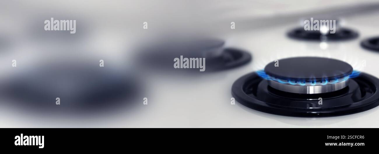 Bruciatore a gas con fiamma blu sul piano cottura, primo piano. Design banner con spazio per il testo Foto Stock