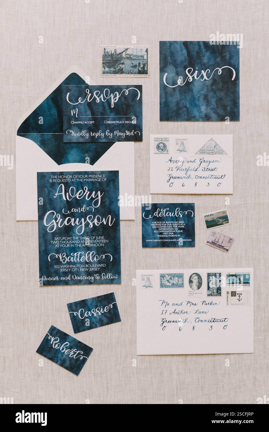 Questa suite per matrimoni presenta un tema blu scuro e un'elegante calligrafia. La raccolta include una busta, schede RSVP e informazioni Foto Stock