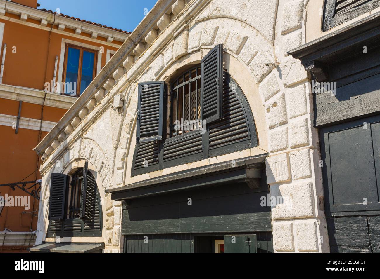 finestra italiana sull'edificio con un muro di pietra Foto Stock