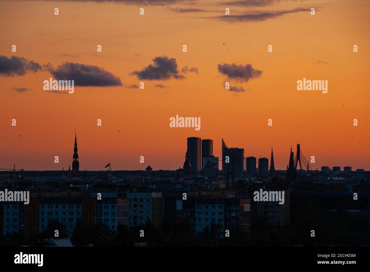 Una silhouette cittadina durante le calde serate estive, al tramonto Foto Stock