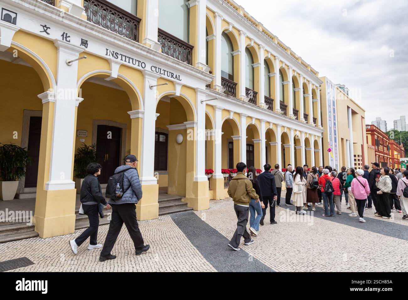 Turisti che esplorano la storica piazza di Macao durante la giornata nuvolosa Foto Stock