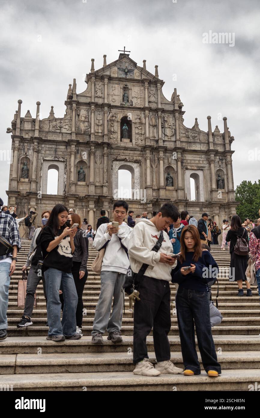 4 turisti asiatici, guardando i loro telefoni presso l'attrazione turistica Foto Stock