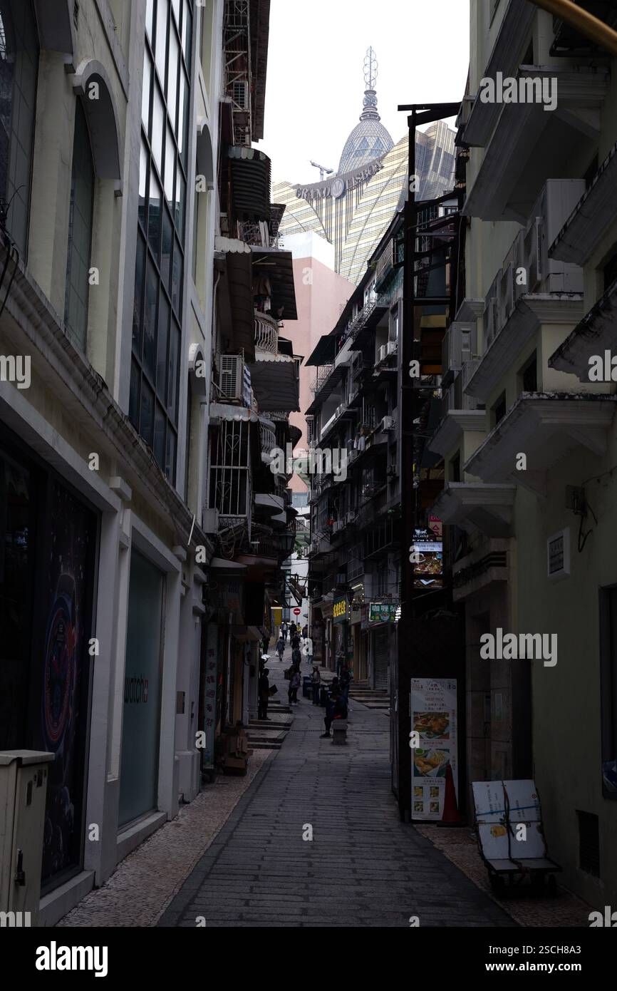 Vicolo scuro con l'edificio Grand Lisboa in fondo Foto Stock