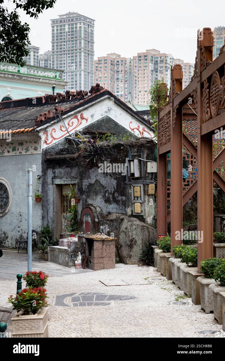 Vecchio albergo abbandonato con edifici alti sullo sfondo Foto Stock
