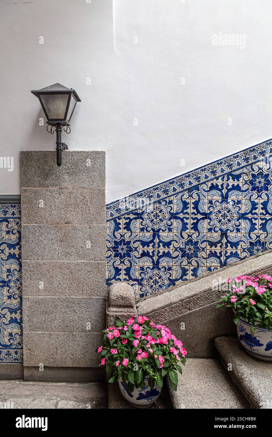 Piastrelle tradizionali portoghesi su scala con vasi di fiori Foto Stock