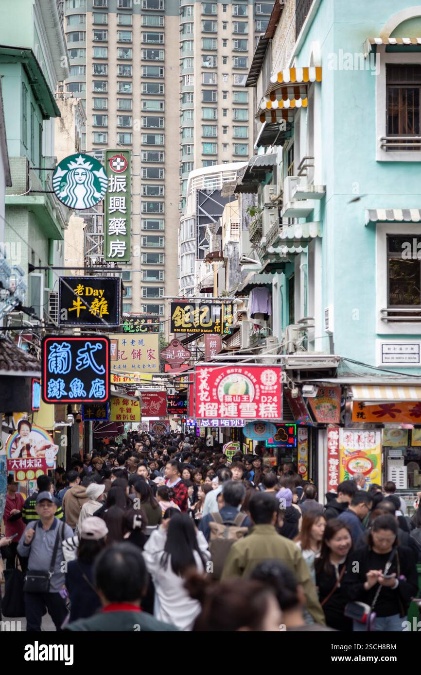 Strada trafficata (Rua do Cunha) a Macao piena di cartelli stradali Foto Stock