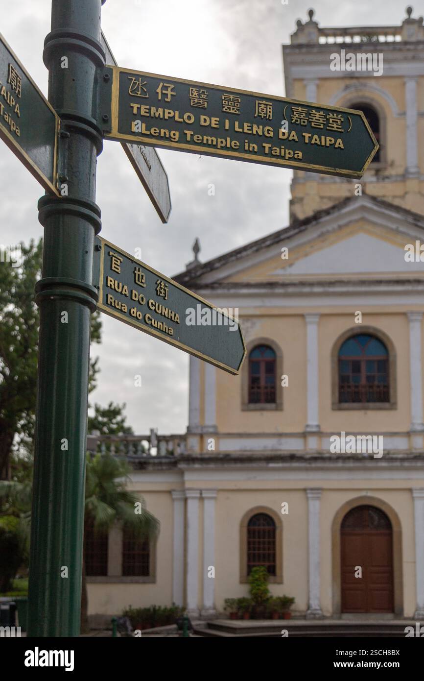 Cartello verde con la chiesa cattolica sullo sfondo Foto Stock