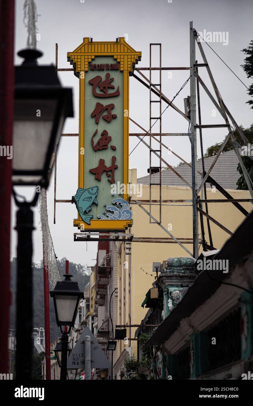 Insegna al neon colorata d'epoca con sopra un pesce, a Macao Foto Stock