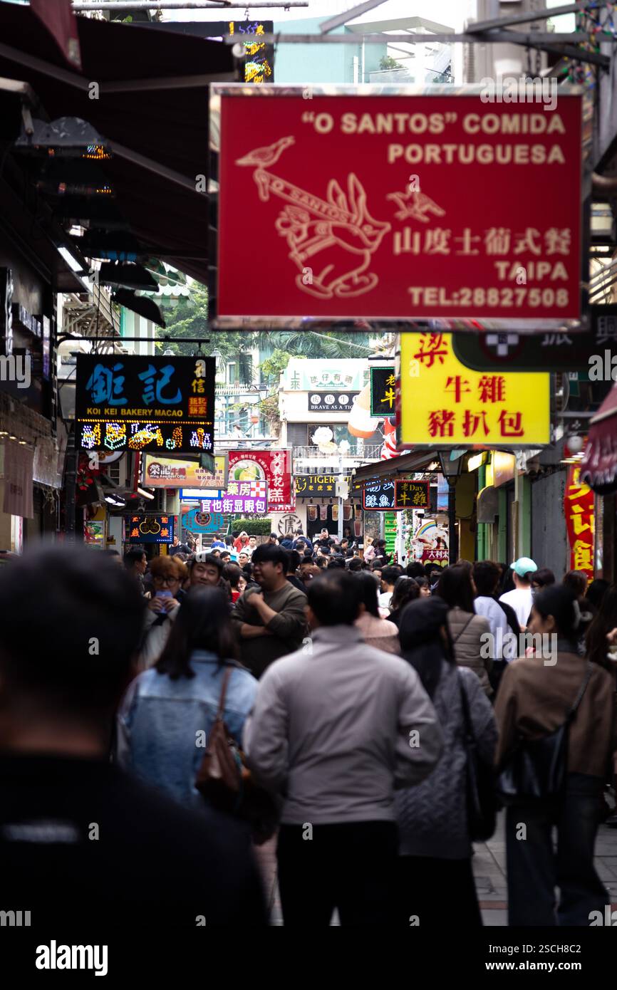 Strada trafficata (Rua do Cunha) a Macao piena di cartelli stradali Foto Stock