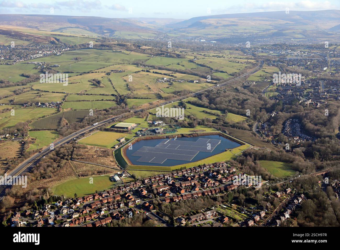 Vista aerea del lago Godley Reservoir e della fattoria solare galleggiante a Hyde, guardando verso Mottram e verso i Pennines in lontananza Foto Stock