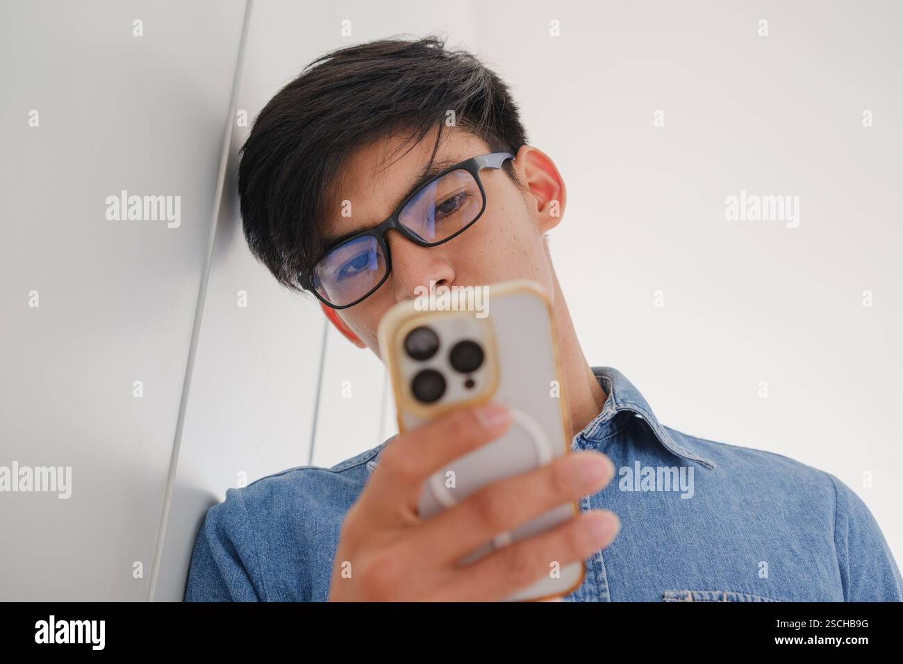 Giovane concentrato che guarda il suo smartphone Foto Stock