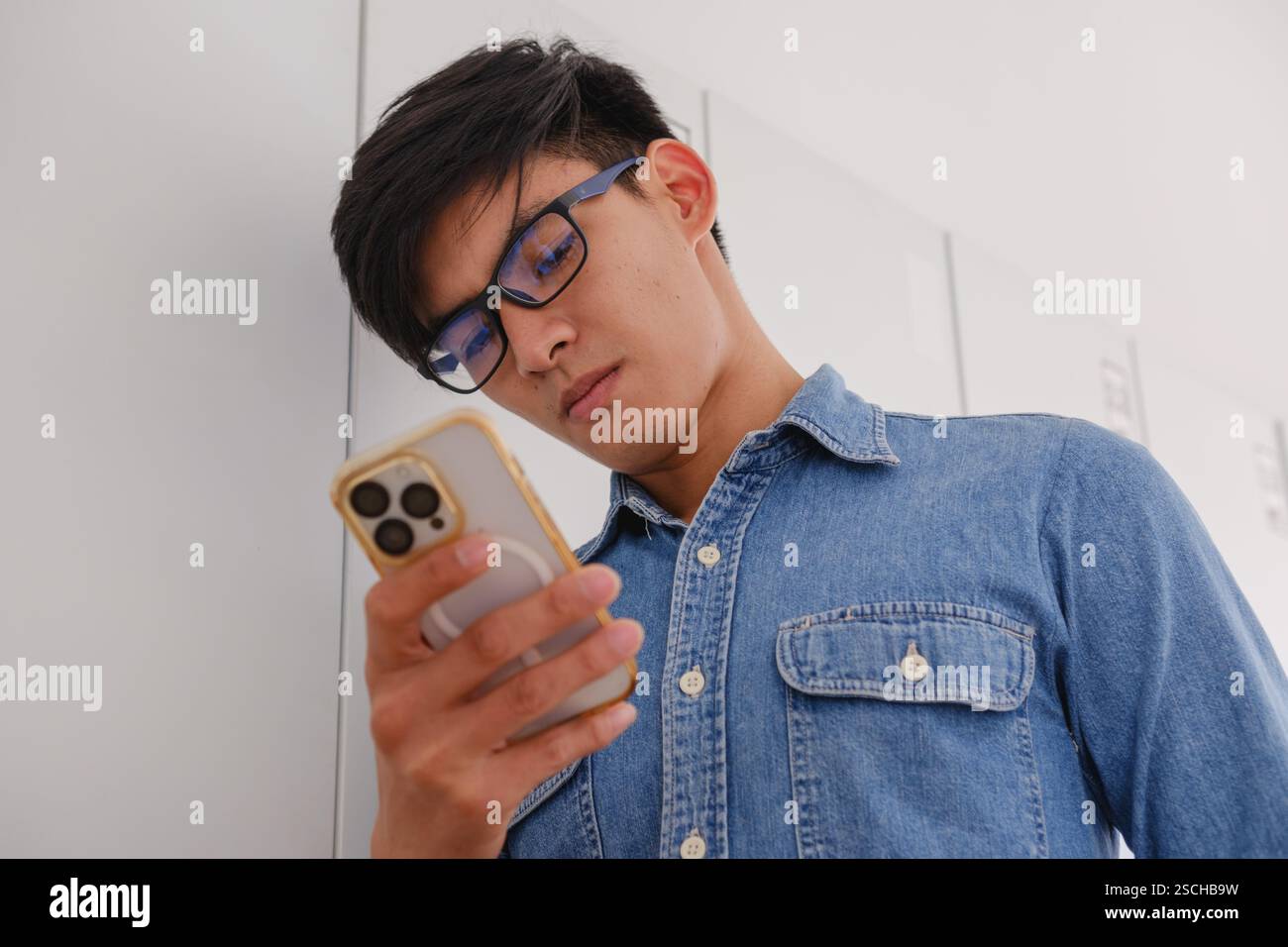 Giovane concentrato che guarda il suo smartphone Foto Stock