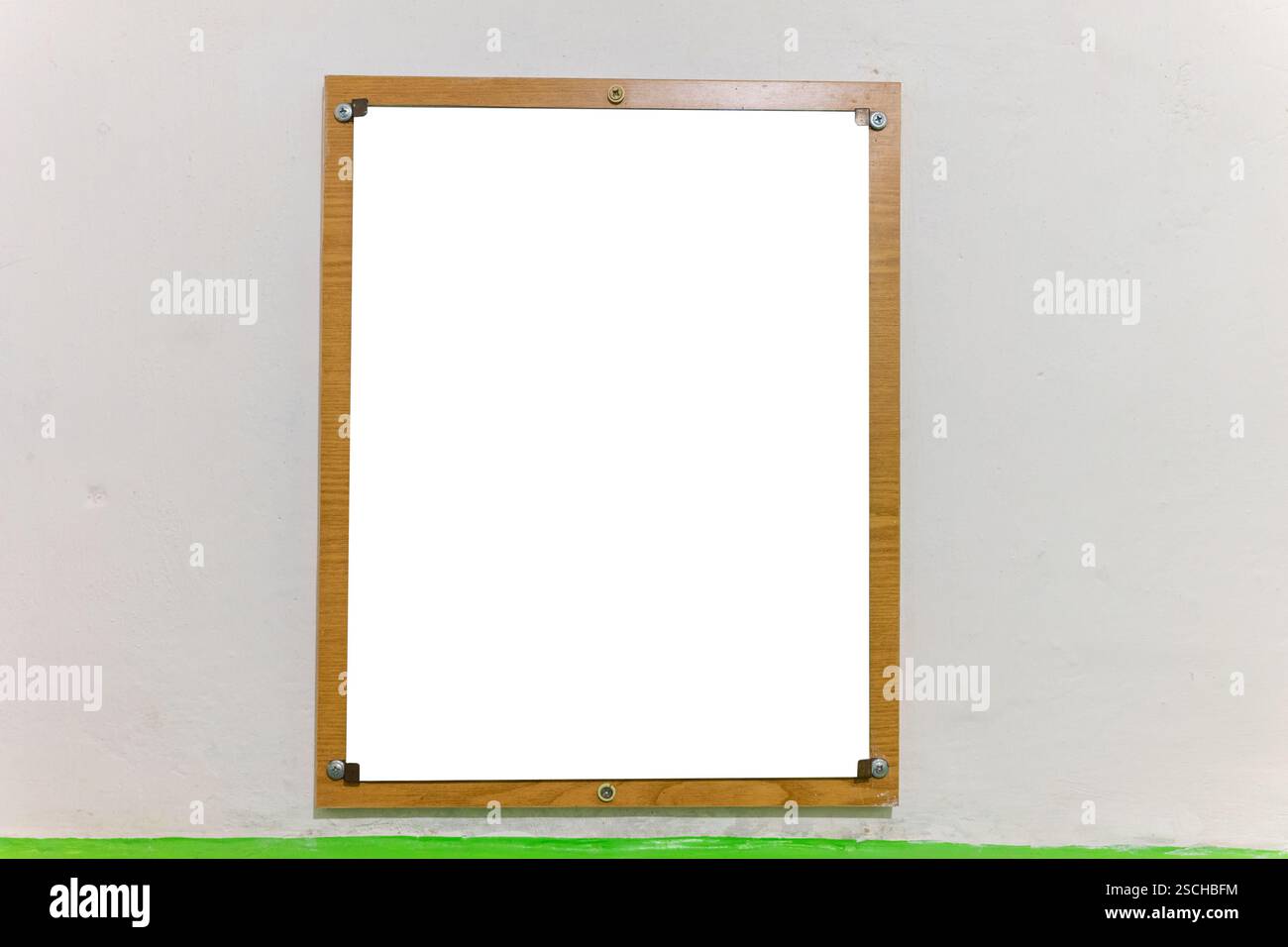 Un semplice telaio in legno con angoli metallici è montato su una parete piana. Lo spazio all'interno della cornice è vuoto, in attesa di aggiungere un'immagine o una decorazione Foto Stock