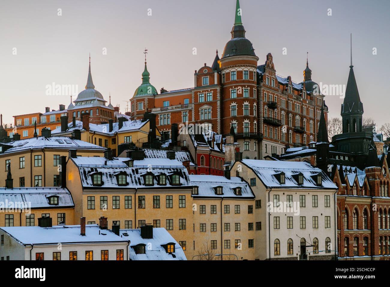 Scopri la splendida architettura di Stoccolma, Svezia, mentre il sole d'inverno tramonta sui tetti innevati e sugli edifici storici, mettendo in risalto i loro Foto Stock