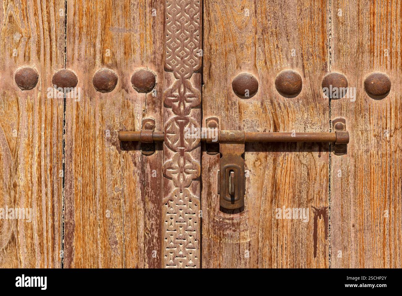 Primo piano di una porta in legno splendidamente lavorata a mano presso il forte Riffa del XVIII secolo a Riffa, Bahrain Foto Stock