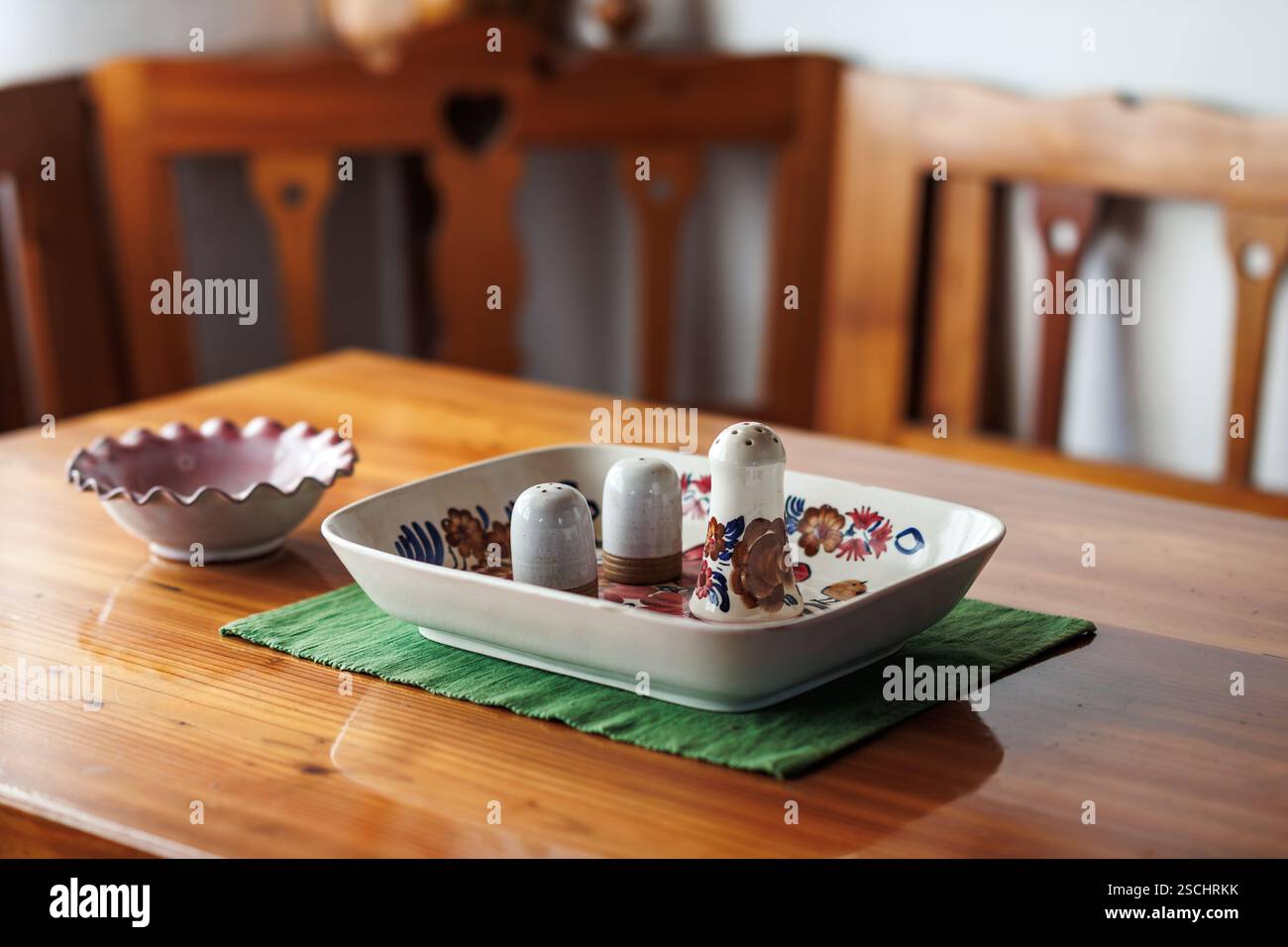 Mobili in legno rustico e agitatore di sale e pepe in ceramica con ciotola su tavolo in legno Foto Stock