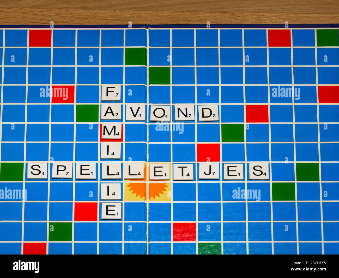 tabellone di scrabble con le parole famiglia, giochi e sera. L'immagine dà l'espressione che stasera è una serata di gioco in famiglia. Lingua olandese Foto Stock