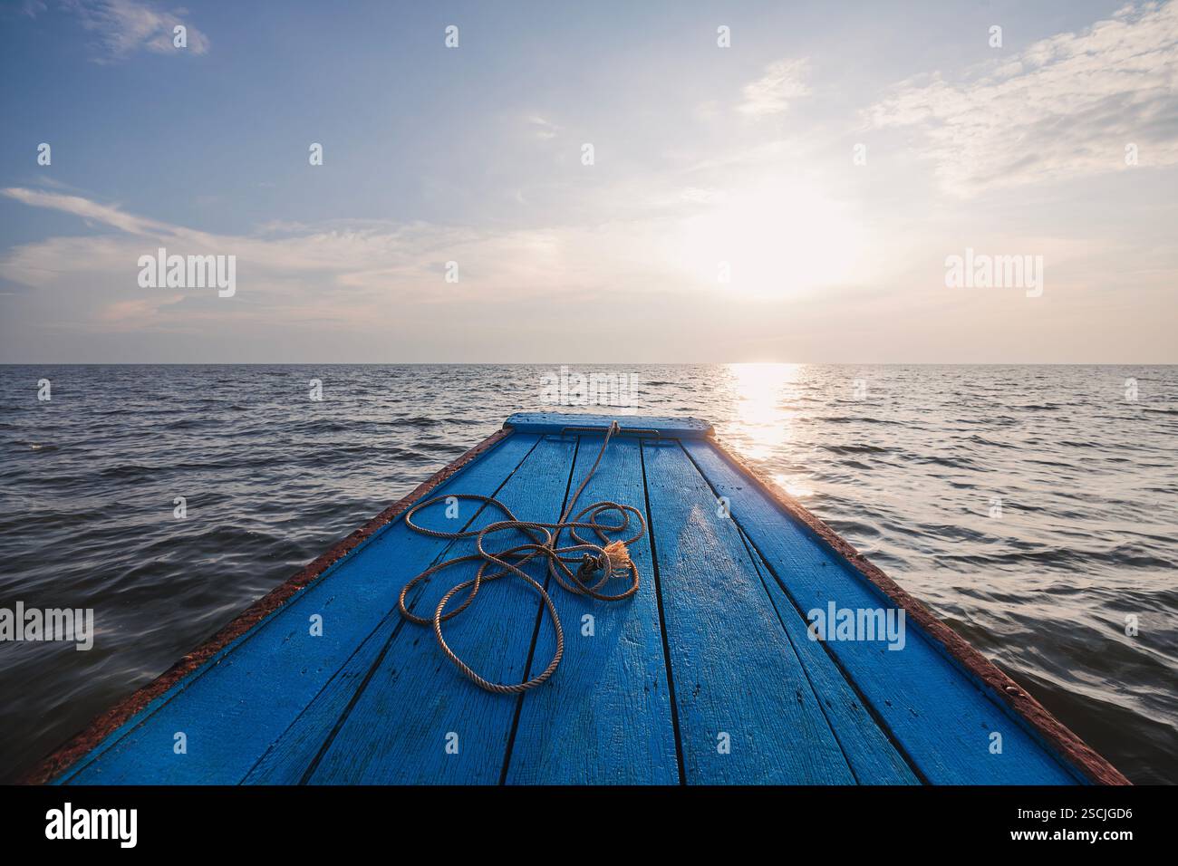Arco di legno della nave con corda in mare aperto contro il tramonto. Temi solitudine, direzione e viaggio. Foto Stock
