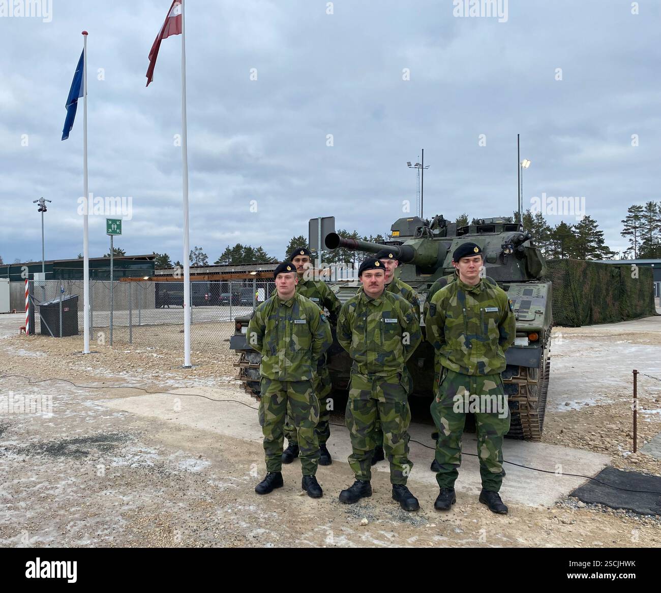 Adazi, Lettonia. 7 febbraio 2025. I soldati svedesi stanno di fronte a un carro armato. Per la prima volta da quando è entrata a far parte della NATO, la Svezia ha stanziato i propri soldati in un altro stato membro della NATO. Per proteggere meglio il fianco orientale della NATO e scoraggiare la Russia, il paese nordico ha schierato circa 500 soldati in Lettonia, che sono stati integrati nella task force multinazionale NATO nello Stato Baltico. Crediti: Alexander Welscher/dpa/Alamy Live News Foto Stock