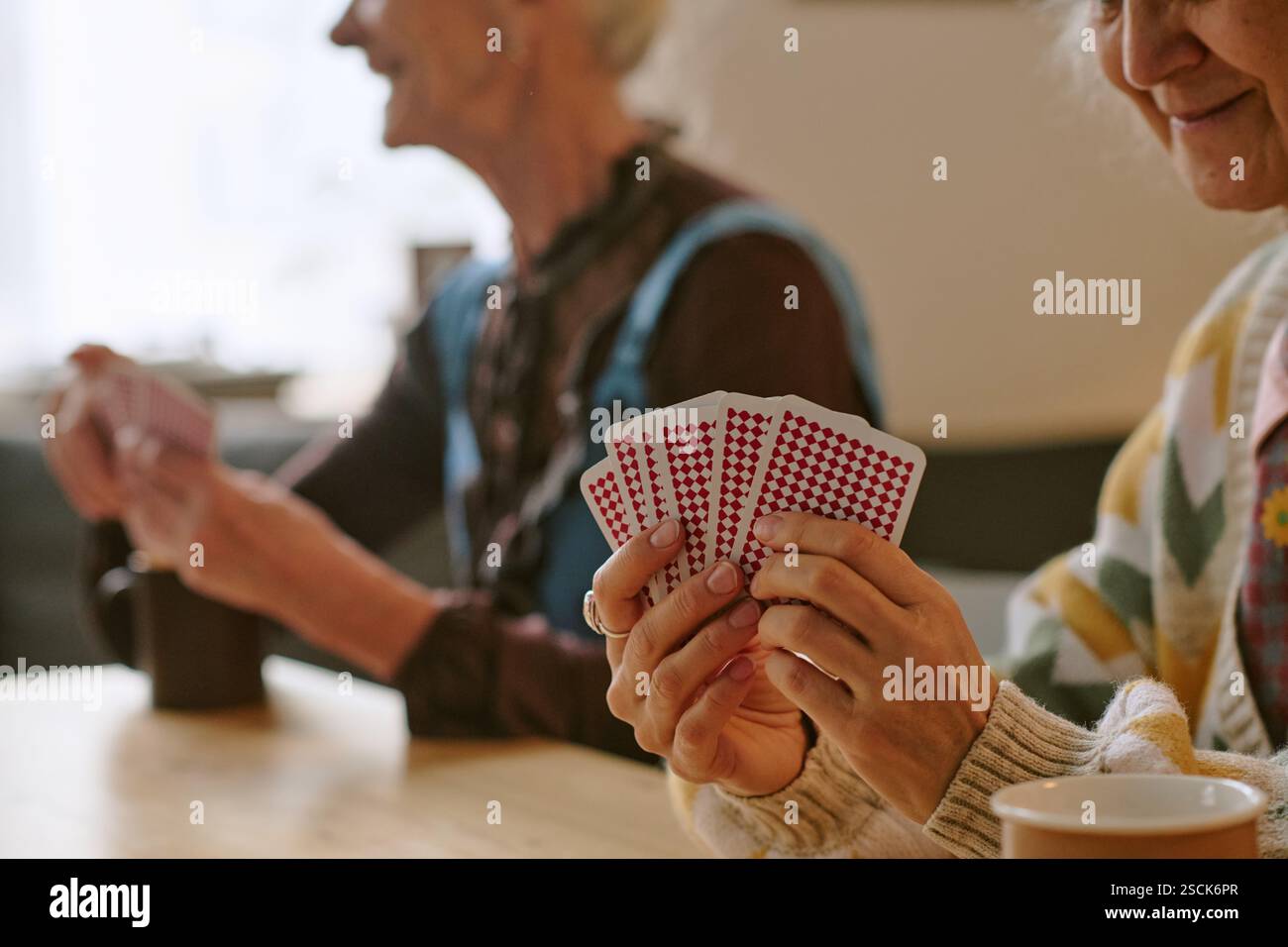 Primo piano medio di una donna anziana irriconoscibile che tiene le carte Foto Stock