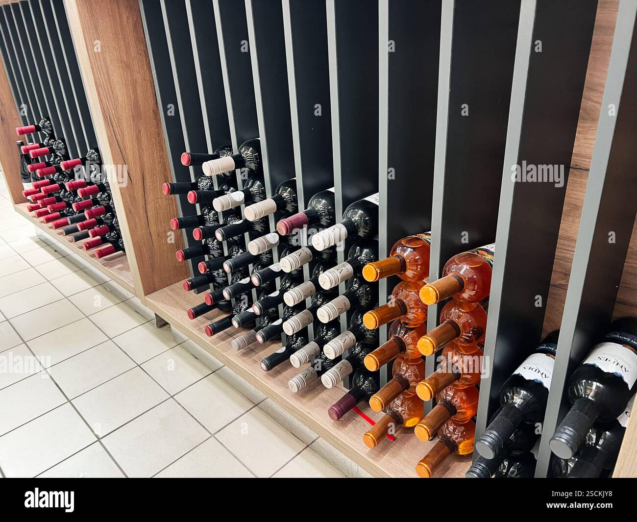 Kiev, Ucraina - 4 febbraio 2025: Un assortimento organizzato di bottiglie di vino in un elegante sistema di scaffalature Foto Stock