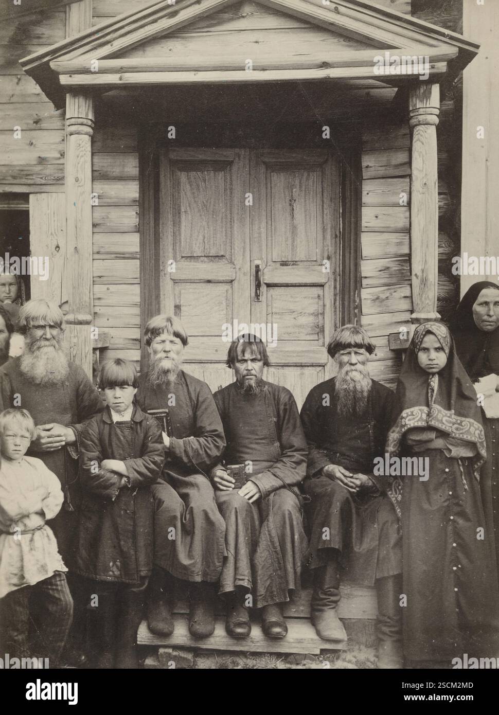 Tipi di dissentori Pomoriani, della Carelia, circa 1910. Ritratto di gruppo di contadini raccolti sui gradini anteriori fuori da una casa di legno. Alcuni di loro tengono dei libri piccoli. Foto Stock