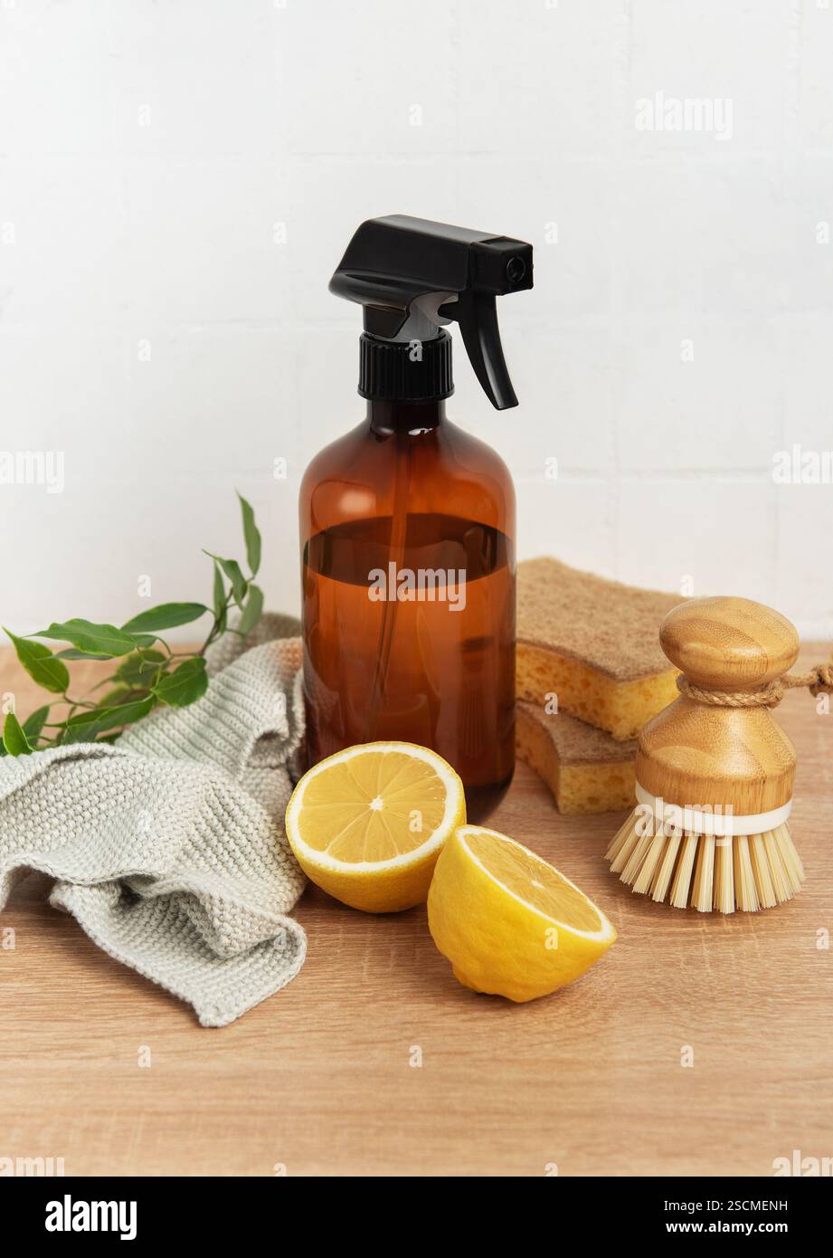 Prodotti per la pulizia naturali, spazzola per piatti, flacone di limone e spray su un tavolo in legno per uno stile di vita sostenibile Foto Stock