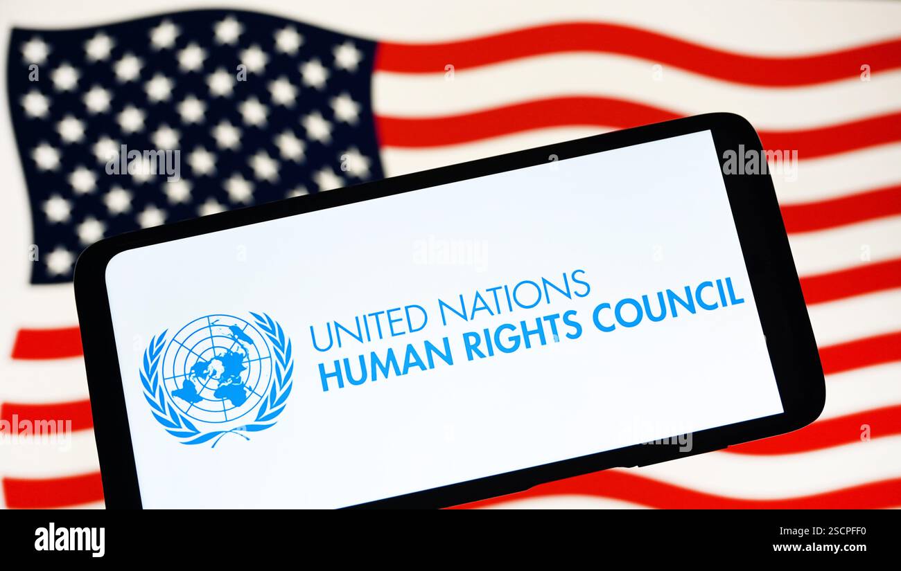 In questa immagine, il logo del Consiglio dei diritti umani delle Nazioni Unite (UNHRC) è visibile su uno smartphone e la bandiera degli Stati Uniti sullo sfondo. Donald Trump ritira gli Stati Uniti dal Consiglio per i diritti umani delle Nazioni Unite, secondo quanto riferito dai media. Foto Stock