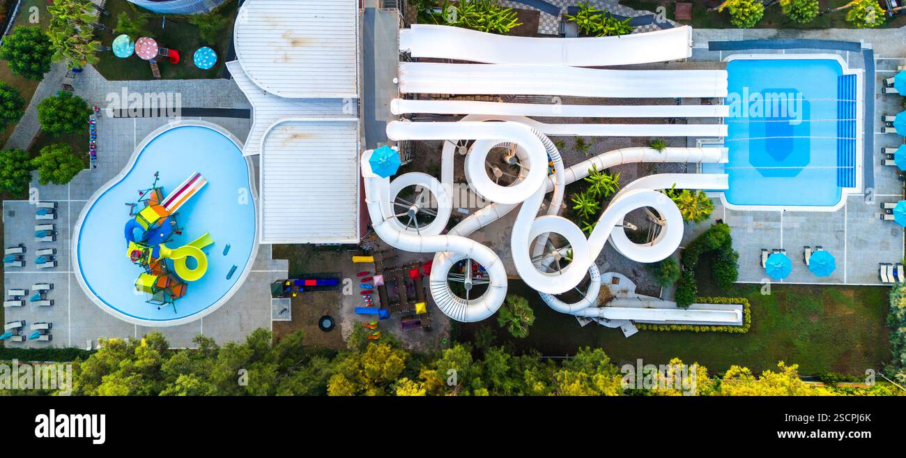 Vista aerea di un parco acquatico con scivoli tortuosi, piscine e un'area giochi per famiglie Foto Stock