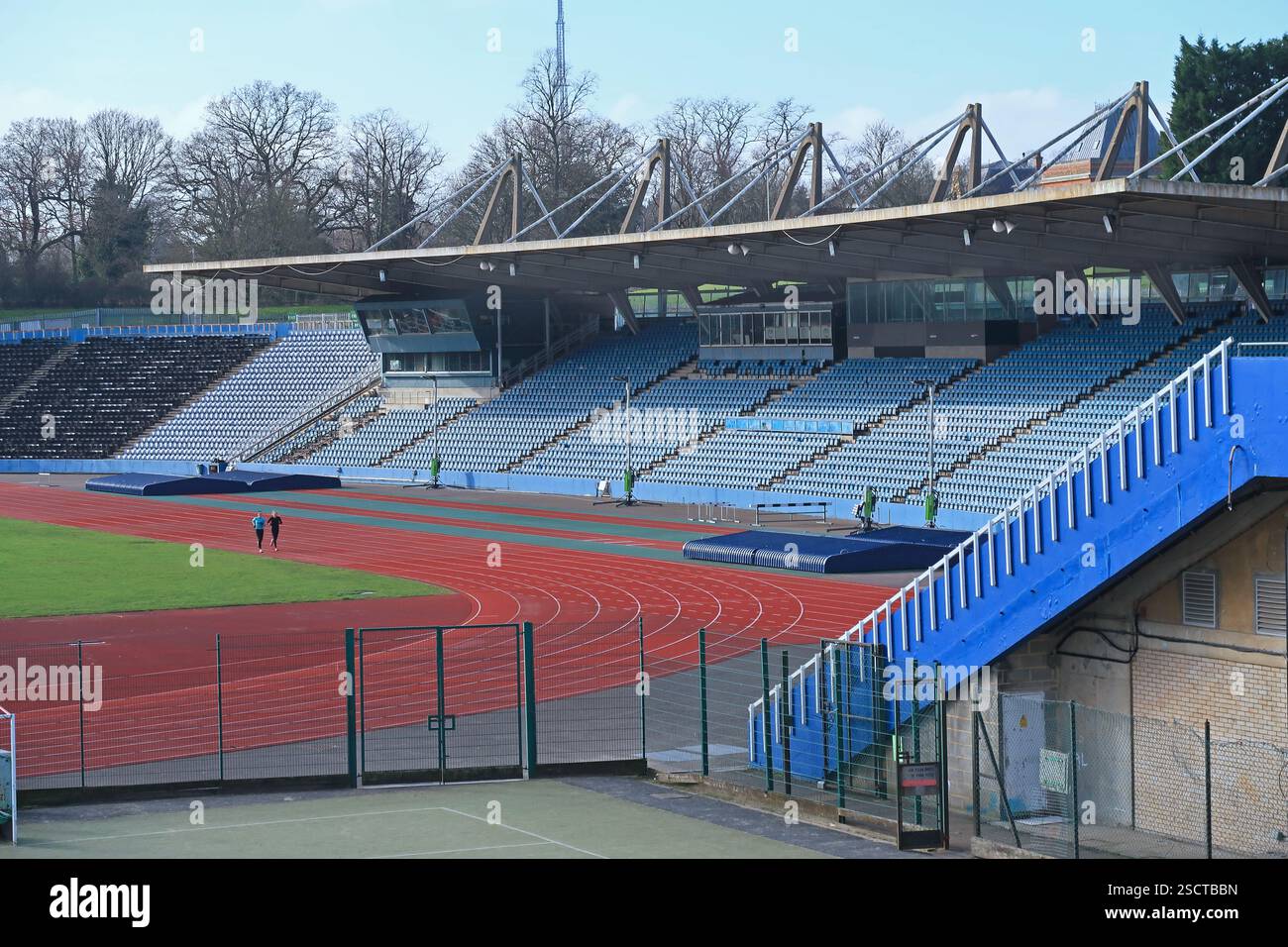 Crystal Palace Athletics Stadium, Londra, Regno Unito. Due corridori si allenano nello stadio vuoto in una soleggiata giornata invernale Foto Stock